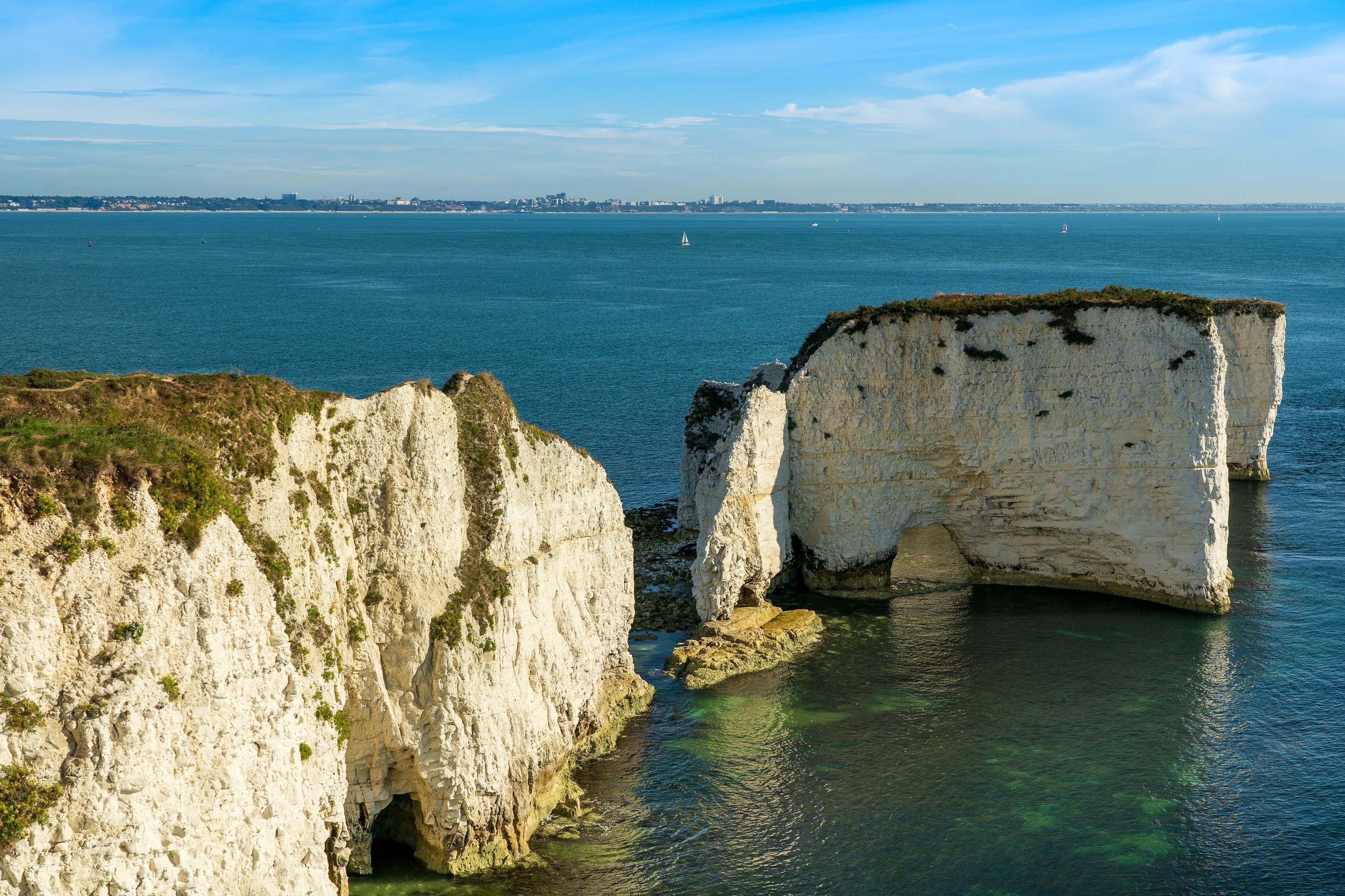 brown rock formation on blue sea under blue sky during daytime